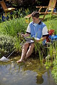 READING AND RELAXING WITH FEET IN GARDEN POND