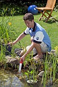CHECKING POND WATER TEMPERATURE WITH THERMOMETER