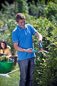 PERSON CUTTING PRUNING HEDGES