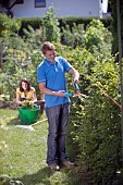 PERSON CUTTING PRUNING HEDGES