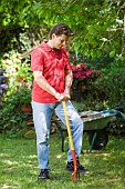 MAN AERATING LAWN WITH FORK