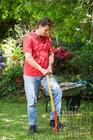 MAN_AERATING_LAWN_WITH_FORK