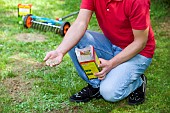 LAWN ACTION SPREADING FERTILISER BY HAND