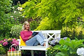 LADY ENJOYING AND RELAXING IN THE GARDEN