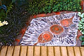 ELABORATE TERRACOTTA PATIO WITH PLANTING; OPHIOPOGON PLANISCAPUS NIGRESCENS, ALCHEMILLA MOLLIS & LAMIA SP.