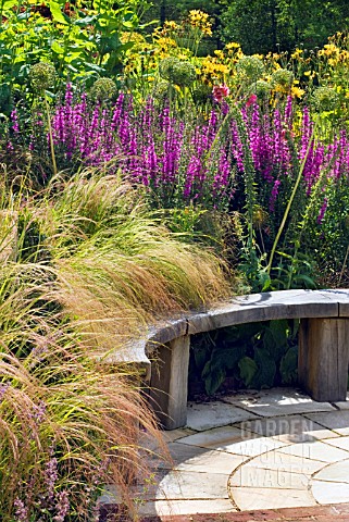 CURVED_WOODEN_BENCH_IN_THE_HERBACEOUS_BORDER_AT_RHS_HARLOW_CARR