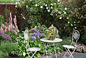 COLOURFUL FRONT GARDEN WITH ORNATE TABLE AND CHAIRS AT WESTON OPEN GARDENS