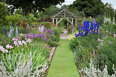 HERBACEOUS_PERENNIALS_WITH_GRASS_PATH_LEADING_TO_OAK_PERGOLA_AT_WOLLERTON_OLD_HALL