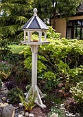 Dovecote in border among mature shrubs