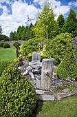 Unusual carved wooden furniture in mature garden