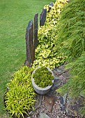 Grey slate pillars in mature garden