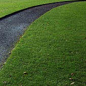 Curved path through lawn in a late autumn garden in November