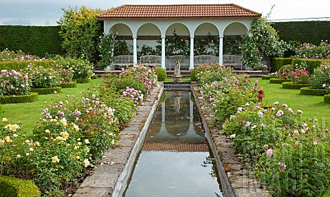 The_Renaissance_Garden_water_garden_edged_with_borders_of_roses_leading_to_seating_area_walls_covere