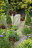 Gravel path with containers leading to gateway garden