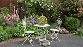 Colourful front garden with ornate table and chairs