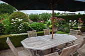 Patio area with wooden garden furniture parasol