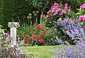 Wide borders of summer flowering herbaceous perennials ornate sun-dial in garden in summer July at Wilkins Pleck (NGS) Whitmore Staffordshire Midlands England UK