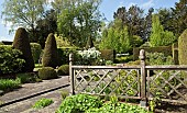 Outstanding country garden with a definite emphasis on strong design and formality this is The rill garden with balls of buxus sempervirens,yew hedges, many mature trees,oak fence resulting linearity creating vistas at Wollerton Old Hall (NGS) Market Drayton in Shropshire mid May Spring