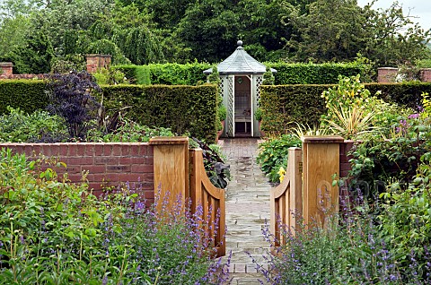 Open_wooden_gate_brick_path_leading_to_summerhouse