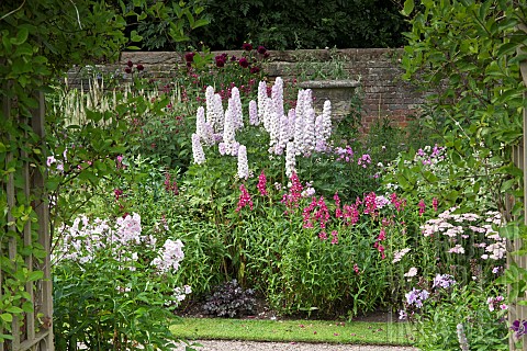 Gateway_looking_out_onto_border_of_of_colour_combination_of_light_to_dark_pinks_herbaceous_perennial