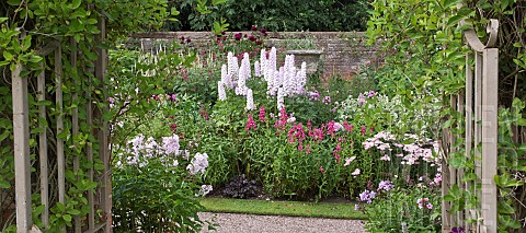 Gateway_looking_out_onto_border_of_of_colour_combination_of_light_to_dark_pinks_herbaceous_perennial