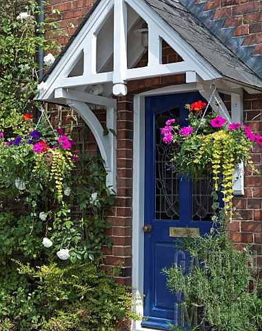 Two_hanging_baskets_of_summer_flowering_annuals_hanging_either_side_of_front_door