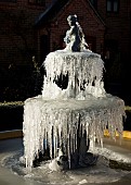 Frozen ornate water fountain and statue