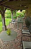 Tables and chairs under the loggia with oak arches and cobbled floors