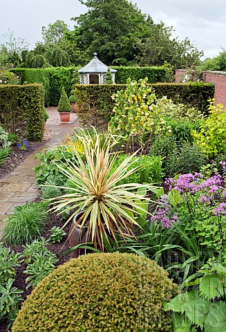 Borders_of_herbaceous_perennials_paths_yew_hedges_summerhouse_mature_trees_in_outstanding_country_ga