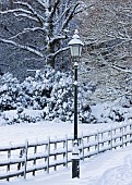 Photograph of snow covered front garden with ornamental gas lamp alongside garden fence.