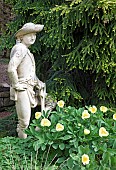 Ornate figure under planted with Paeonia Wittmanniana Peony