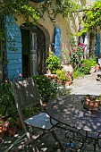 PROVENCAL FARMHOUSE TERRACE WITH BLUE SHUTTERS AND VARIOUS POTPLANTS, SUNNY