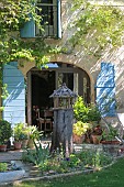 PROVENCAL MAS HOUSE, BIRD TABLE, IRISSES AND NIGELLA, VARIOUS POTS, CLIMBING ROSE ON WALL