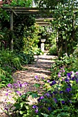 GRAVEL PATH COVERED BY PERGOLA LEADING TO FORMAL URN ON STAND