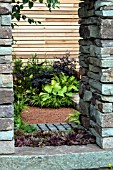 GARDEN VIEW THROUGH AN OPENING IN ASTONE WALL