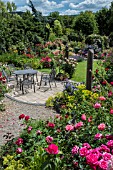 GARDEN PATIO AREA SURROUNDED WITH ROSES WITH PERENNIALS