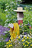 WOODEN FIGURE CARRYING A WATER HOSE