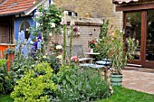 PERENNIAL BORDER AND TERRACE IN A BACKYARD GARDEN. DESIGN: JUTTA WAHREN