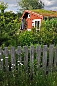 GARDEN HOUSE WITH GREEN ROOF IN A NATURAL GARDEN