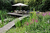 WOODEN DECKING AREA WITH SEATS AT A SWIMMING POND