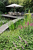 WOODEN DECKING AREA WITH SEATS AT A SWIMMING POND