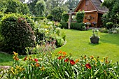 WOODEN HOUSE WITH LAWN AND PERENNIAL BEDS. DESIGN: MARIANNE AND DETLEF LUEDKE