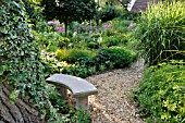 SMALL STONE BENCH IN A PERENNIAL GARDEN. DESIGN: MARIANNE AND DETLEF LUEDKE