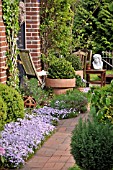 FRONT GARDEN WITH SEATING AREA AND FLOWER TUBS