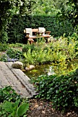 GARDEN BENCH AT A POND WITH A STONE BRIDGE. DESIGN: MARIANNE AND DETLEF LUEDKE