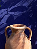 STONEWARE JUG IN FRONT OF A BLUE WALL