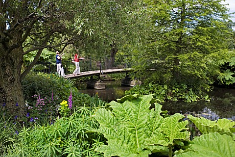 VISITORS_CROSS_THE_BRIDGE_AT_THE_LOWER_POND_IN_THE__RHS_GARDEN__HYDE_HALL