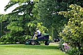 MOWING THE LAWN AT RHS GARDEN HYDE HALL,  IN JUNE.