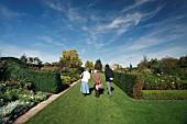 VISITORS STROLL THROUGH THE MODERN  ROSE GARDEN AND HERBACEOUS BORDERS AT RHS GARDEN HYDE HALL,  IN OCTOBER
