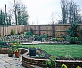 NEW GARDEN IN DEVELOPMENT APRIL,  VIEW ACROSS THE LAWN TO POND AND ROCKERY.